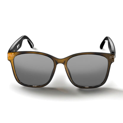 A pair of Smart glasses with a translucent amber-brown acetate frame, dark gray lenses, and black temple tips, shown against a plain white background.
